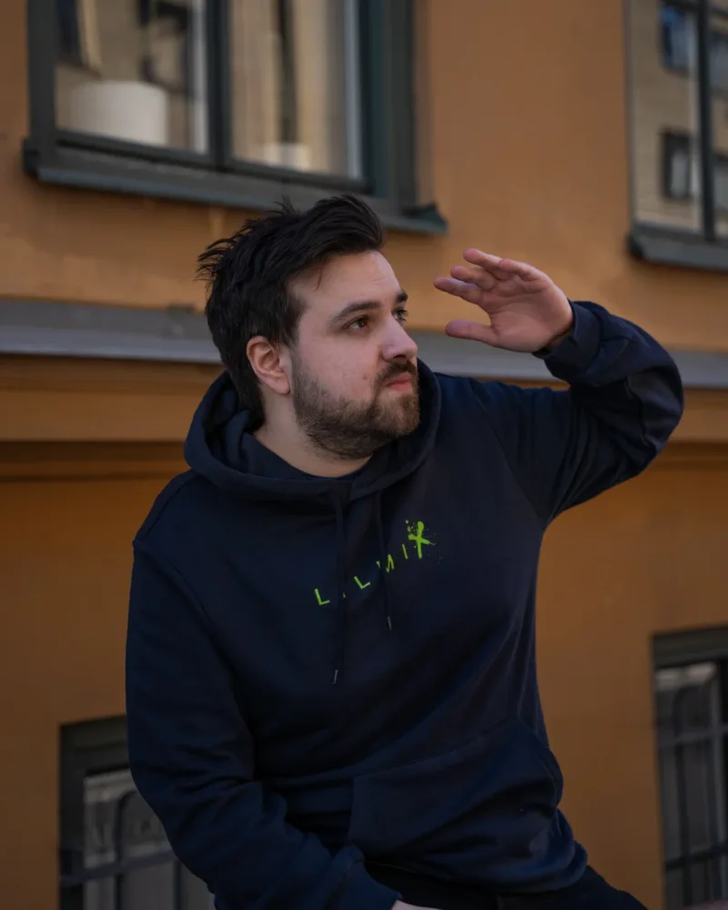 Navy Lilmix Hidden Monkey Hoodie with the green LILMIX chest print, worn on a sunny street